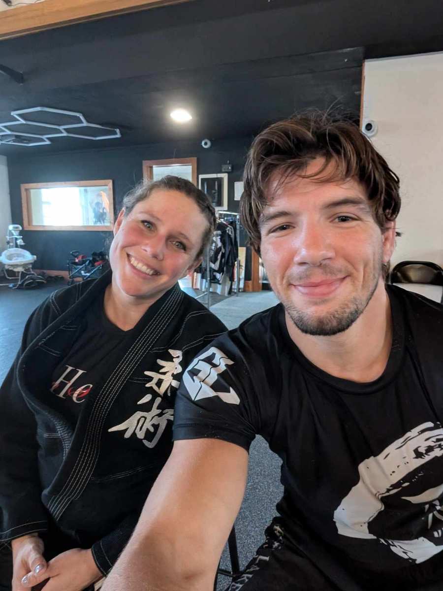 Two adult jiu-jitsu practitioners smiling after training at Great Lakes BJJ in Flint