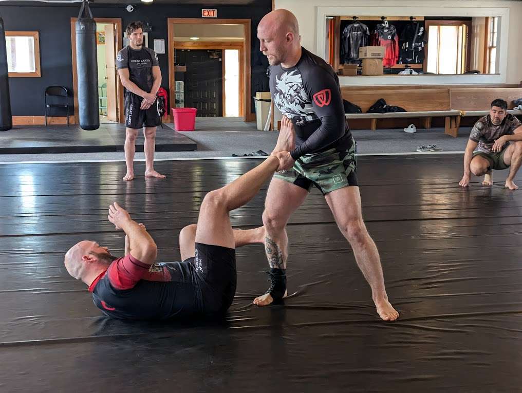 Adult grapplers practicing a standing guard pass during no-gi training at Great Lakes BJJ in Flint